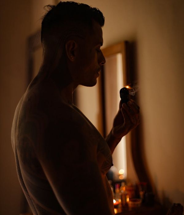 Person meditating in a calm, dark environment with cyan ambient light.